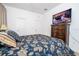 Relax in this cozy main bedroom, featuring a comfortable bed, dark wood dresser, and a wall-mounted TV at 4561 Cabello Loop, Kissimmee, FL 34746