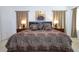 Bright and spacious main bedroom featuring a king bed, matching lamps, decorative art, and beige carpeting at 4561 Cabello Loop, Kissimmee, FL 34746