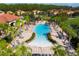 Community pool and surrounding community area with many lounge chairs and tropical trees at 4561 Cabello Loop, Kissimmee, FL 34746