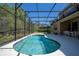 Backyard pool with screened enclosure, featuring outdoor seating area and view of the home at 4561 Cabello Loop, Kissimmee, FL 34746