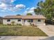 Inviting single-story home with a lush green lawn, stone facade, and charming front porch with bench at 4905 Tam Dr, Orlando, FL 32808