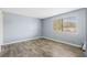An empty bedroom with vinyl floors, one window and light-blue walls at 4907 Silver Oaks Vlg # D, Orlando, FL 32808