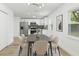 Bright dining room with modern light fixture, dining table, and adjacent kitchen at 5603 Marie Ct, Orlando, FL 32818