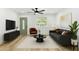 Cozy living room features a modern ceiling fan, sleek furniture and light wood floors at 5603 Marie Ct, Orlando, FL 32818