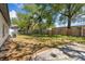 A large backyard featuring a wooden fence and mature trees providing shade and privacy at 5603 Marie Ct, Orlando, FL 32818