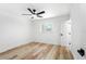 Clean bedroom featuring light wood floors, a ceiling fan, and natural light from the window at 5603 Marie Ct, Orlando, FL 32818