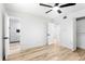 Bright bedroom with a ceiling fan, light wood flooring, and an open door to the bathroom at 5603 Marie Ct, Orlando, FL 32818