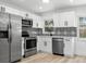 Modern kitchen featuring stainless steel appliances, white cabinets, and stylish backsplash at 5603 Marie Ct, Orlando, FL 32818