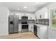 Modern kitchen featuring stainless steel appliances, white cabinets, and stylish backsplash at 5603 Marie Ct, Orlando, FL 32818
