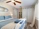 Comfortable bedroom features a ceiling fan, natural light, and stylish wood-look floors at 6013 Thames Way, Orlando, FL 32807