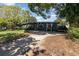 Front view of home with charming porch and mature trees, American flag, ample parking at 6013 Thames Way, Orlando, FL 32807