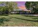 Charming single-story home featuring a well-manicured lawn and mature trees, enhancing curb appeal at 6013 Thames Way, Orlando, FL 32807