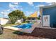 Backyard features a sparkling swimming pool, a sunshade sail, patio furniture, and a well-manicured lawn at 6013 Thames Way, Orlando, FL 32807