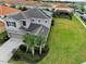 Aerial shot of a gray two-story home with large backyard, surrounded by neighborhood homes, a tile roof, and solar panels at 6049 Broad Oak Dr, Davenport, FL 33837