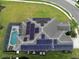 Aerial view of a roof with solar panels, a pool, pool enclosure, and lawn at 6049 Broad Oak Dr, Davenport, FL 33837