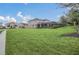 Expansive backyard featuring lush green grass, landscaping, and a screened-in patio, ideal for outdoor enjoyment at 6049 Broad Oak Dr, Davenport, FL 33837