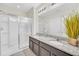 Bright bathroom boasts double vanity with granite countertop and glass enclosed shower at 6049 Broad Oak Dr, Davenport, FL 33837
