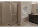 Bathroom with enclosed shower and separate tub with dark cabinets and granite countertops at 6049 Broad Oak Dr, Davenport, FL 33837