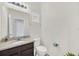 Clean bathroom featuring granite countertop vanity, toilet, and a framed travel art print at 6049 Broad Oak Dr, Davenport, FL 33837