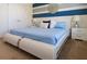 Modern bedroom features a white platform bed with blue accents and matching nightstands at 6049 Broad Oak Dr, Davenport, FL 33837
