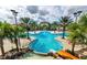 Stunning resort-style community pool with a water slide, palm trees, and ample seating for relaxation and recreation at 6049 Broad Oak Dr, Davenport, FL 33837