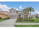 Inviting two-story home with well-manicured lawn, showcasing tropical landscaping and a neutral color scheme at 6049 Broad Oak Dr, Davenport, FL 33837