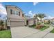 Attractive two-story home featuring a well-maintained lawn, tropical trees, and a convenient two-car garage at 6049 Broad Oak Dr, Davenport, FL 33837