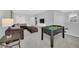 Carpeted game room with a foosball table, sofa, ottoman, and wall-mounted TV at 6049 Broad Oak Dr, Davenport, FL 33837