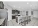 Spacious kitchen featuring modern appliances, granite countertops, a large island, and sleek dark cabinetry at 6049 Broad Oak Dr, Davenport, FL 33837