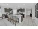 Modern kitchen featuring dark cabinets, granite countertops, and a large island with seating at 6049 Broad Oak Dr, Davenport, FL 33837
