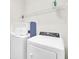 Convenient laundry area featuring a washer, dryer, and storage shelves at 6049 Broad Oak Dr, Davenport, FL 33837