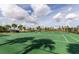 Well-maintained community tennis court ready for a friendly match, set against a backdrop of palm trees and blue skies at 6049 Broad Oak Dr, Davenport, FL 33837