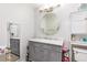 Bathroom featuring gray vanity with marble countertop, round mirror, and modern lighting at 698 Seabrook Ct # 103, Altamonte Springs, FL 32714