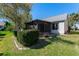 Backyard with a screened-in patio and neatly trimmed shrubs and grass at 704 Sky Tree Ct, New Smyrna Beach, FL 32168