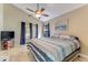 Bright bedroom with a ceiling fan, blue striped bedding, and patio access at 704 Sky Tree Ct, New Smyrna Beach, FL 32168