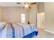 Bedroom with a view of a bright bathroom; has a ceiling fan and blue bedding at 704 Sky Tree Ct, New Smyrna Beach, FL 32168