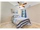Comfortable bedroom with blue-striped bedding, a ceiling fan, and natural light at 704 Sky Tree Ct, New Smyrna Beach, FL 32168