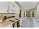 Bright kitchen area featuring white cabinets, tile floors, and stainless steel appliances at 704 Sky Tree Ct, New Smyrna Beach, FL 32168