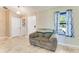 Cozy sitting area featuring a comfortable couch, window with curtains, and tile flooring at 704 Sky Tree Ct, New Smyrna Beach, FL 32168