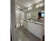 Bathroom featuring double sink, granite countertops, shower with glass door, and sleek modern design at 8008 Formosa Valley Pl, Kissimmee, FL 34747