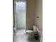 Bright bathroom featuring toilet, sink, gray tile flooring, and direct access to outdoor patio at 8008 Formosa Valley Pl, Kissimmee, FL 34747