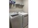 Functional laundry room with washer, dryer, and shelving for organized storage of supplies at 8008 Formosa Valley Pl, Kissimmee, FL 34747