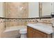 Elegant bathroom featuring a tub with glass enclosure, textured tile, and a modern vanity with a stone countertop at 801 W 2Nd Ave, Windermere, FL 34786