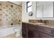 Cozy bathroom featuring a glass-enclosed tub and shower, vanity with granite countertop, and neutral tile flooring at 801 W 2Nd Ave, Windermere, FL 34786