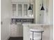 Stylish wet bar featuring glass cabinets, marble countertops, under-cabinet drawers, and modern pendant lighting at 801 W 2Nd Ave, Windermere, FL 34786