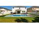 Landscaped backyard featuring a pool with spa, outdoor seating, and green lawn perfect for relaxation and entertaining at 8010 Soldierwood St, Winter Garden, FL 34787