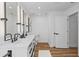 Bright bathroom featuring a double vanity with sleek fixtures, modern mirrors, and neutral tones at 8010 Soldierwood St, Winter Garden, FL 34787
