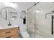 Modern bathroom featuring a wooden vanity, round mirror, and glass-enclosed shower with white tile at 8010 Soldierwood St, Winter Garden, FL 34787
