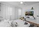 Bright bedroom featuring a queen size bed with decorative pillows and a TV, plus sheer white curtains for privacy at 8010 Soldierwood St, Winter Garden, FL 34787