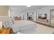 Inviting bedroom with a queen bed, a padded bench, warm lighting, and an adjacent home office through double doors at 8010 Soldierwood St, Winter Garden, FL 34787